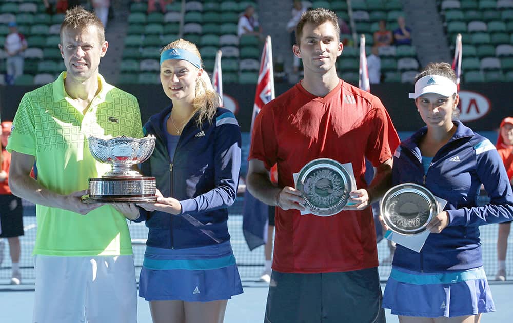 Kristina Mladenovic of France and Daniel Nestor of Canada, hold the trophy along with second placed Sania Mirza and Horia Tecau of Romania, after winning their mixed doubles final at the Australian Open tennis championship in Melbourne.