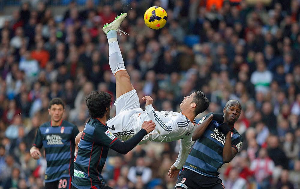 Real Madrid`s Cristiano Ronaldo from Portugal, top, tries to score in between opposition players during a Spanish La Liga soccer match between Real Madrid and Granada at the Santiago Bernabeu stadium in Madrid.