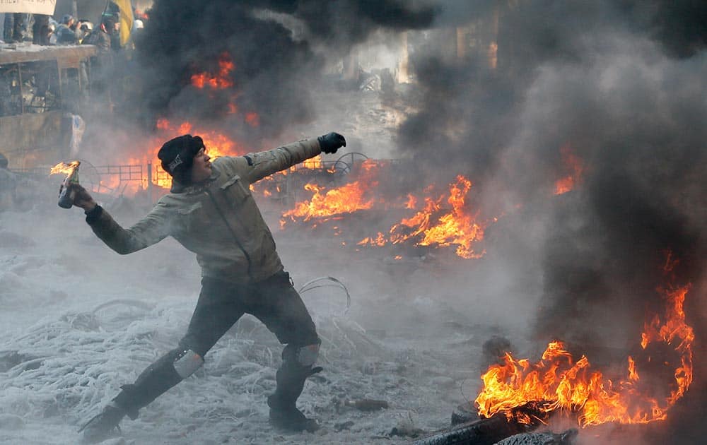 A protester throws a Molotov cocktail towards riot police during a clash in central Kiev, Ukraine.