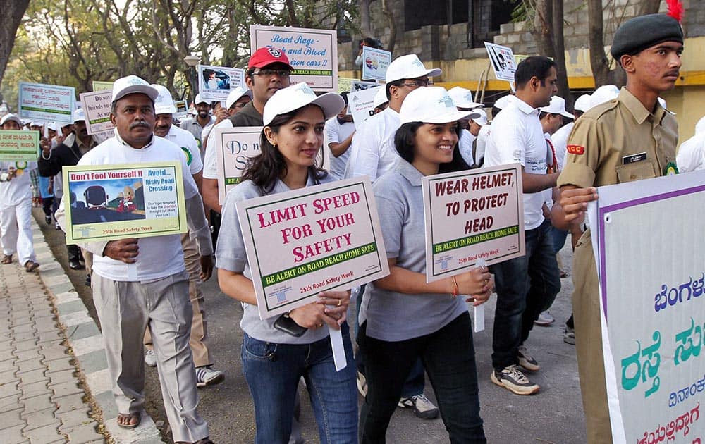 Volunteers hold placards as they take part in a Walkathon as part of the 25th National Road Safety Week in Bengaluru.