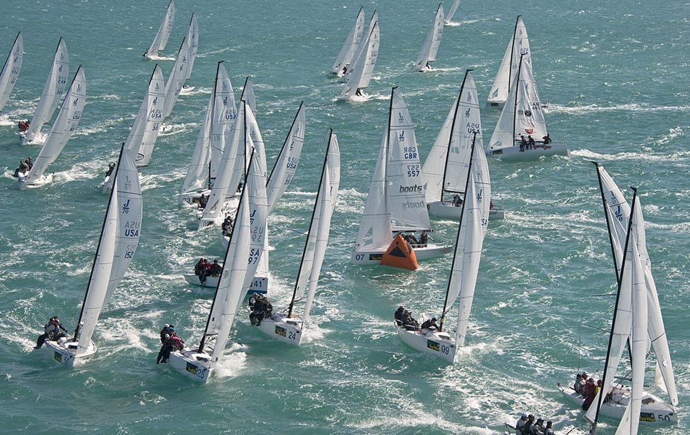 This aerial photo provided by the Florida Keys News Bureau, J/70 boats crowd the windward mark during the final day of racing at the Quantum Key West sailing regatta, in Key West, Fla.
