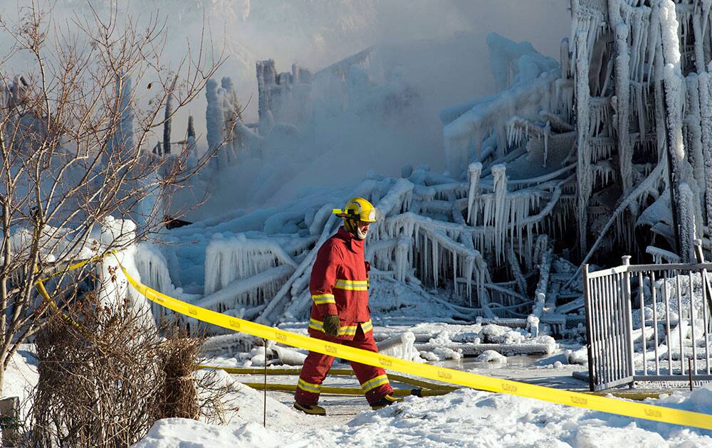 A firefighter walks past the rubble where fire destroyed a a seniors residence in L`Isle-Verte, Quebec.