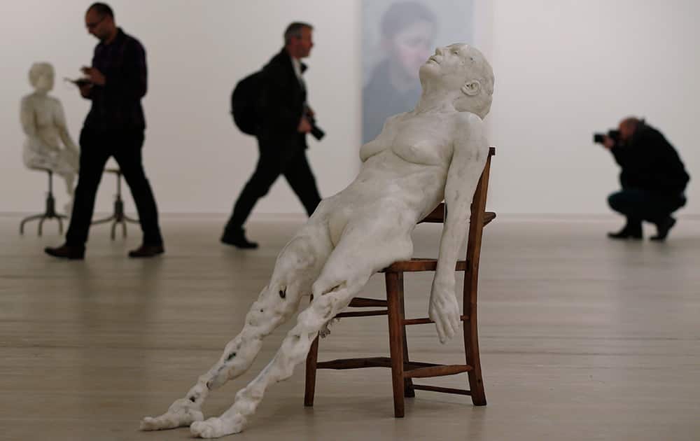 Members of the media walk around a 2013 art piece made of mixed wax and marble powder by artist Virgile Ittah entitled: `Regarding the Pain of the Other` is displayed at the Saatchi Gallery in London.