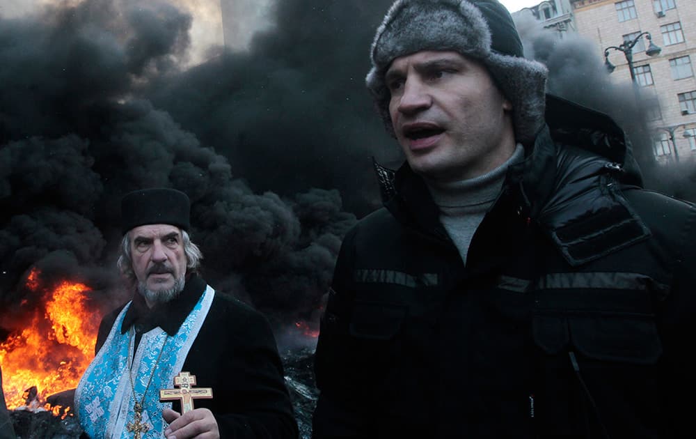 Opposition leader and former WBC heavyweight boxing champion Vitali Klitschko addresses protesters near the burning barricades between police and protesters in central Kiev, Ukraine.
