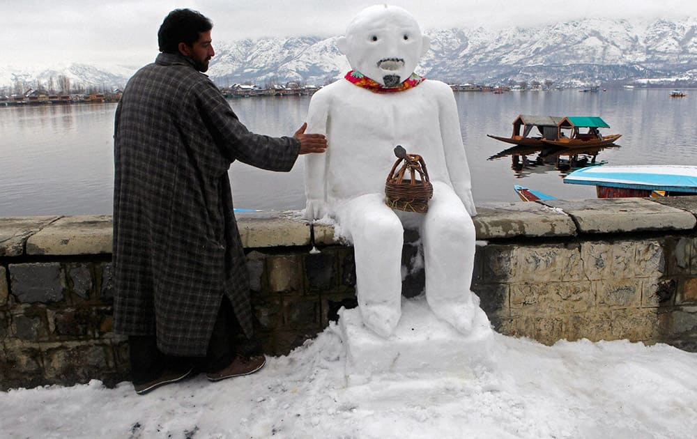 A boatman giving finshing touch to a snow man after heavy snow fall, on banks of Dal Lake in Srinagar.