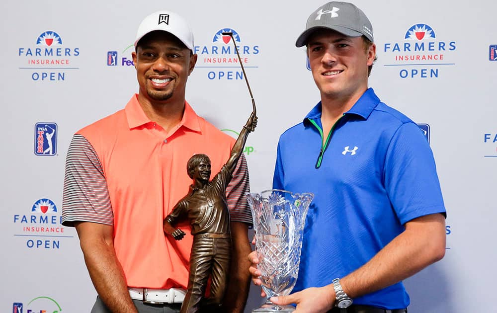 Tiger Woods, 2013 PGA Tour Player of the Year and Jordan Spieth, PGA Tour Rookie of the Year, pose with their trophies during a presentation at a news conference at the Farmers Insurance Open golf tournament at Torrey Pines Golf Course, in San Diego.