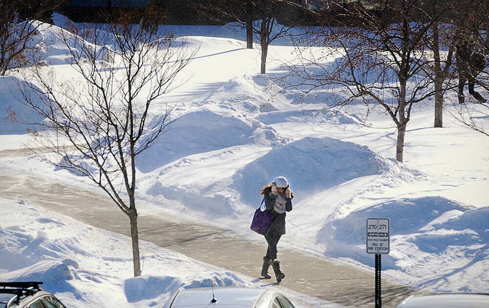 Students and faculty do their best to protect themselves from the wind and cold as they walk around at St. Cloud State University between classes in St. Cloud, Minn.