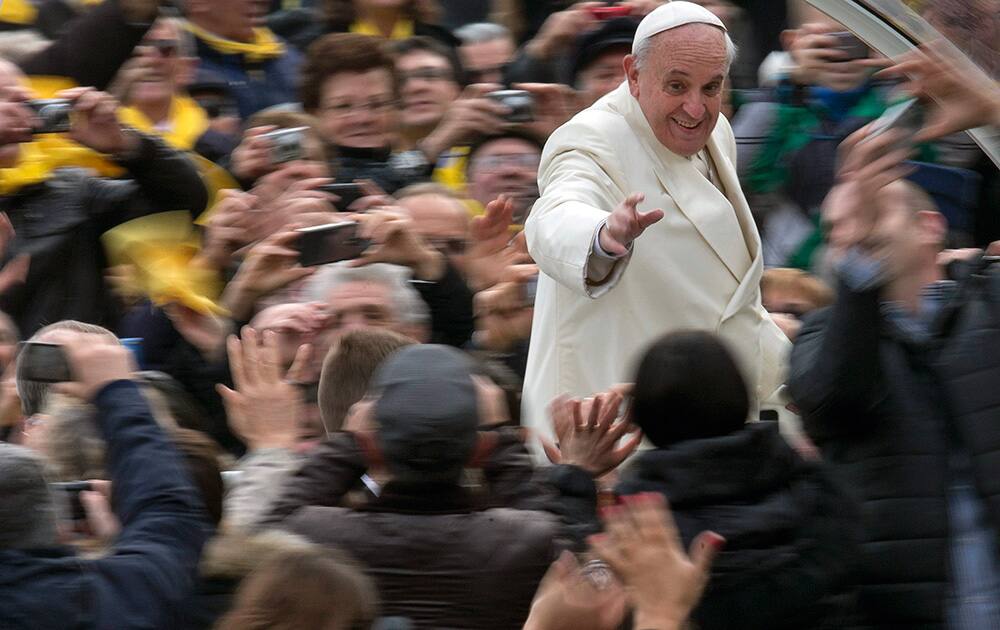 Pope Francis waves to faithful from his pope-mobile as he arrives for his weekly general audience in St. Peter`s Square at the Vatican.