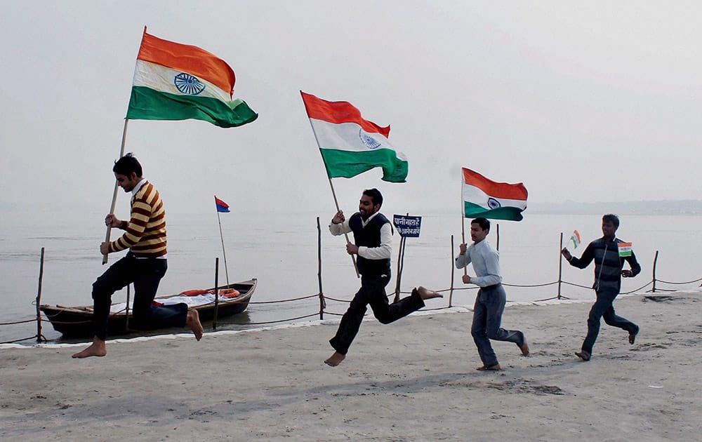 Youths run with Indian National Flags at Sangam ahead of Republic Day celebration in Allahabad.