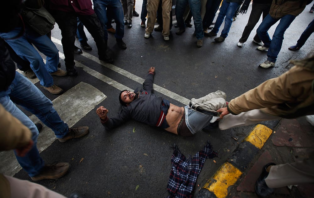 A police man drags a supporter of New Delhi Chief Minister Arvind Kejriwal, who was injured during clashes with police during a demonstration against the police in New Delhi.