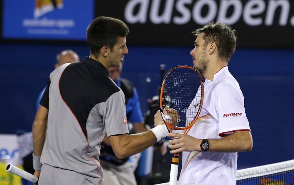 Stanislas Wawrinka of Switzerland, right, is congratulated by Novak Djokovic of Serbia at the net after his win in their quarterfinal at the Australian Open tennis championship in Melbourne, Australia.