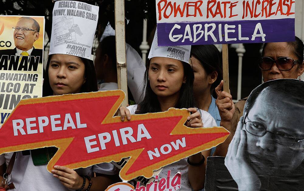 Protesters display placards and portraits of President Benigno Aquino III, as they hold a rally at the Philippine Supreme Court to coincide with the oral arguments on the power rates hike petition of Meralco, the country`s largest electric power distributor, in Manila, Philippines.