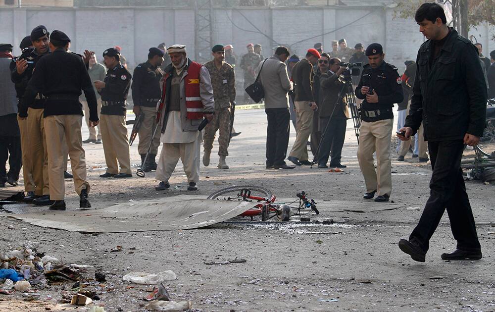 Pakistani security officials examine the site of a suicide bombing in Rawalpindi, Pakistan. A Taliban suicide bomber blew himself up not far from Pakistan’s military headquarters Monday, killing nine people a day after a militants bombing inside an army compound in the northwest of the country, officials and militants said.