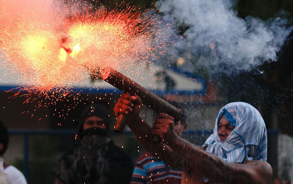 A relative of the former worker of the Ingenio San Antonio, ISA, fires a homemade mortar during protests in Chichigalpa, Nicaragua.
