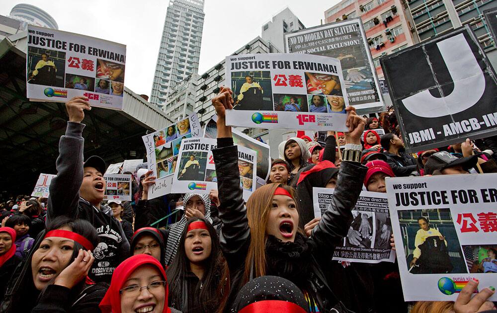 Domestic helpers and their supporters shout slogans while holding pictures of 23-year-old Indonesian maid Erwiana Sulistyaningsih during a protest in Hong Kong.