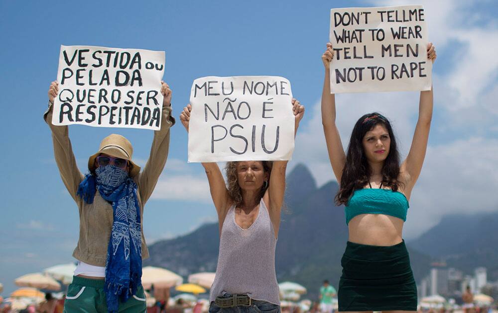Women who belong to the Bastardxs Movement hold protest signs on Ipanema beach in Rio de Janeiro, Brazil.