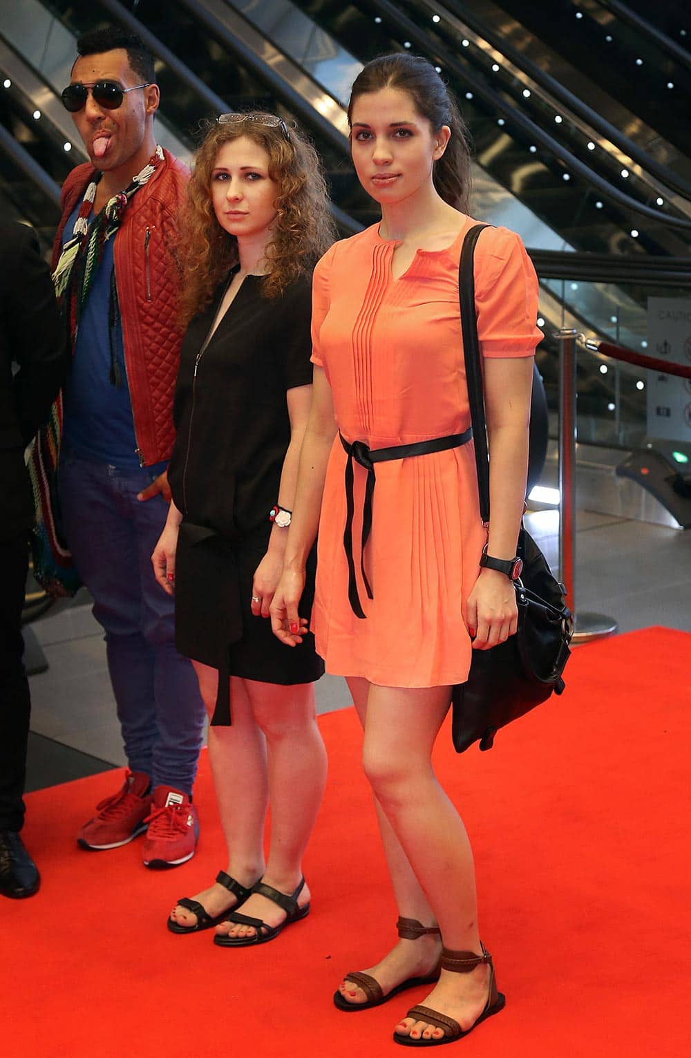 Russian punk band Pussy Riot members Nadezhda Tolokonnikova and Maria Alekhina pose with Australian artist Eric Bridgeman, as they arrive on Saturday, Jan. 18, 2014 for the Prudential Eye Awards in Singapore.