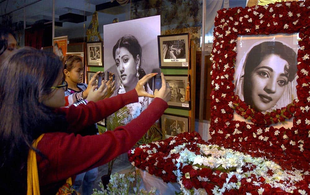 Fans take pictures of the decorated potraits of legendary actress Suchitra Sen at Rabindra Sadan in Kolkata on Friday. Sen died in Kolkata hospital after suffering heart attack.
