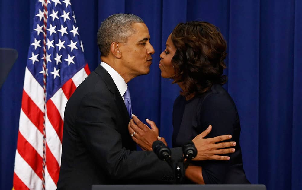 President Barack Obama leans over to kiss first lady Michelle Obama after she introduced him after speaking about college education, in the Eisenhower Executive Office Building on the White House complex in Washington.