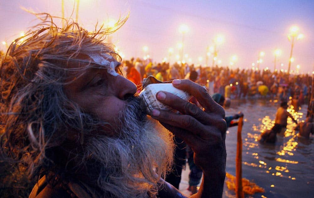 A sadhu blowing a conch shell after taking dip at Sangam on the occasion of Paush Purnima in Allahabad.