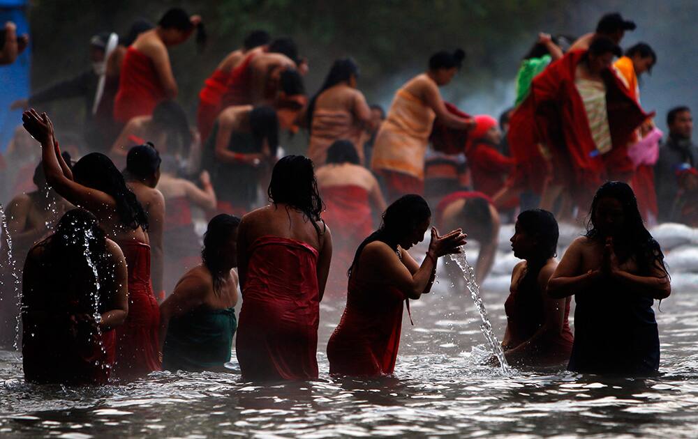 Nepalese Hindu women take holy dips at the Salinadi River on the first day of month long Madhav Narayan Festival, in Sankhu, northeast of Katmandu, Nepal.