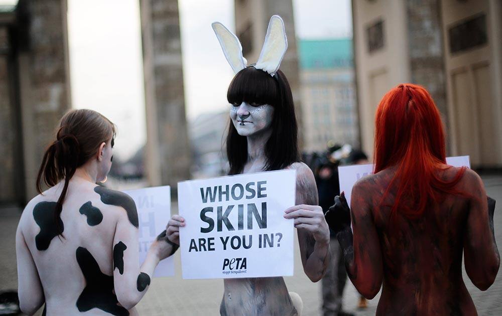 Three protesters of the animal right organization Peta show posters against use of furs in the fashion industry prior to the launch of the Mercedes Benz Fashion Week for Autumn Winter 2014, in Berlin.