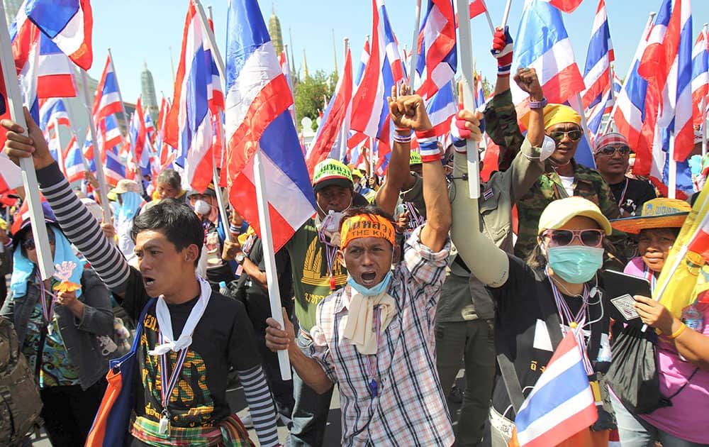 Anti-government protesters hold national flags and shout slogans during a rally in front of Grand Palace in Bangkok, Thailand.