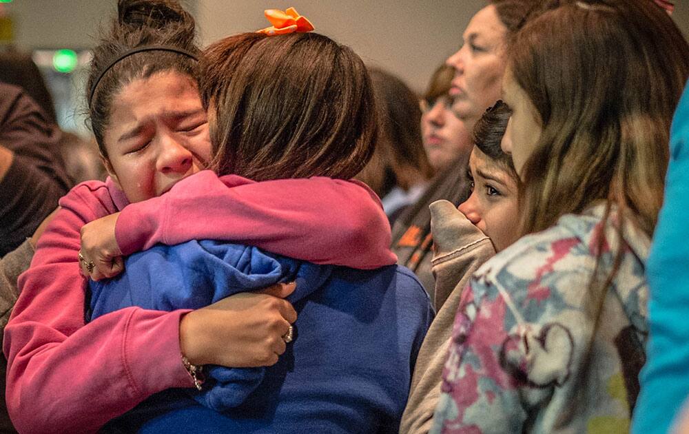 Thirteen year old Kimberly Macias cries as she sees schoolmates at a vigil for the victims, in Roswell, N.M. A 12-year-old New Mexico boy drew a shotgun from a band-instrument case and shot and wounded two classmates at his middle school Tuesday morning before a teacher talked him into dropping the weapon and he was taken into custody, officials and witnesses said.