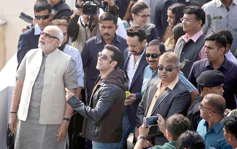Bollywood actor Salman Khan, flies a kite as Gujarat state Chief Minister Narendra Modi and others watch during the kite festival Uttarayan in Ahmedabad.