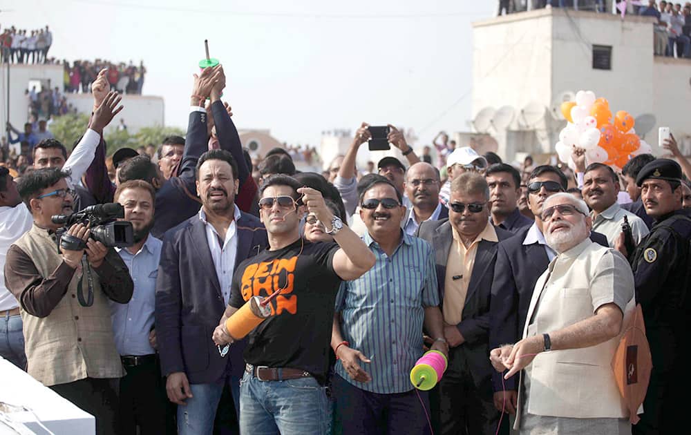 Bollywood actor Salman Khan, flies a kite as Gujarat state Chief Minister Narendra Modi and others watch during the kite festival Uttarayan in Ahmedabad.