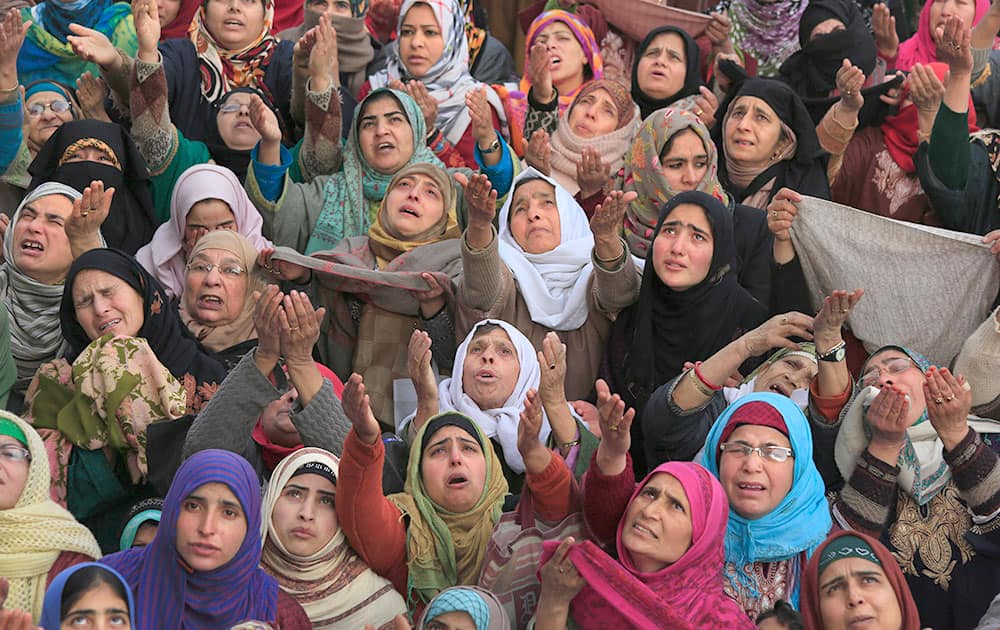 Kashmiri Muslim devotees raise their hands in prayer as a head priest displays a relic of Prophet Muhammad at the Hazratbal shrine on Eid-e-Milad, or birth anniversary of the prophet, in Srinagar.