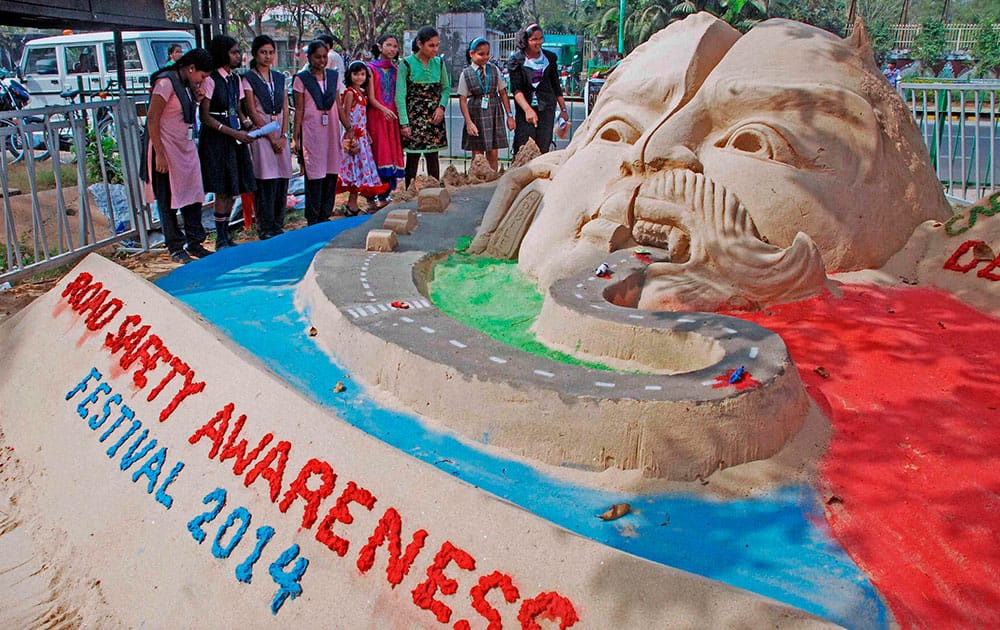 School children look at the sand sculpture during the on going Road safety awaereness week 2014 in Bhubaneswar.