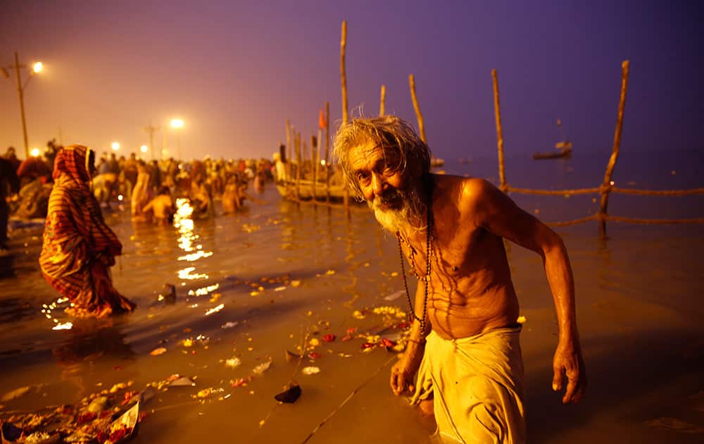 An elderly Hindu devotee reacts to camera after a holy dip at Sangam, the confluence of rivers Ganges and Yamuna on Makar Sankranti festival which also marks the beginning of Magh Mela, in Allahabad.