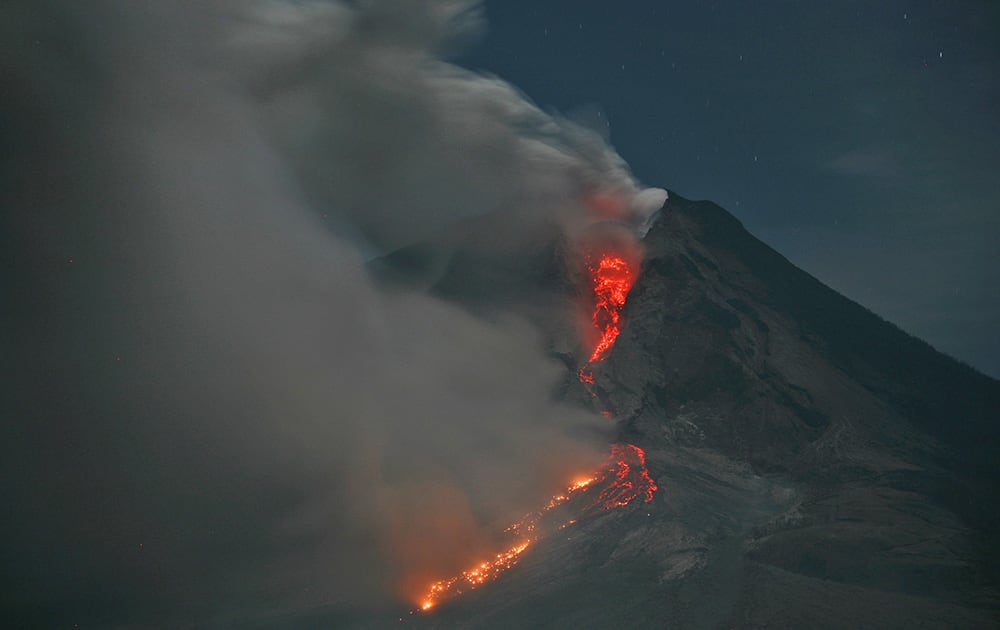 Mount Sinabung erupts with molten rocks and hot gasses as seen from Jeraya, North Sumatra, Indonesia. The volcano has sporadically erupted since September, forcing thousands of people who live around it slopes to flee their homes.