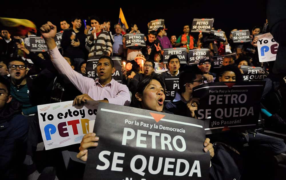 Supporters of Bogota`s Mayor Gustavo Petro hold signs reading in Spanish: `Petro Stays,` in front of the city hall in Bogota, Colombia.