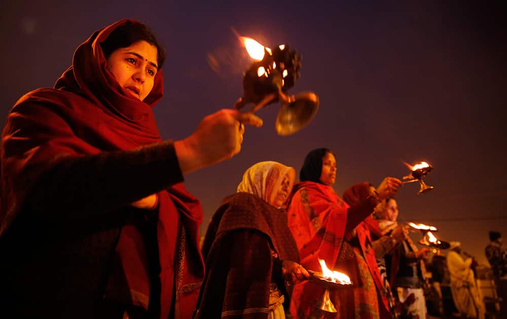 Hindu devotees perform evening rituals on the eve of the Makar Sankranti festival at Sangam, the confluence of rivers Ganges and Yamuna in Allahabad