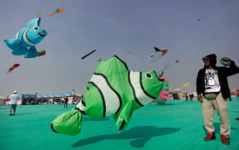 A man flies a huge fish-shaped kite during a kite festival in Ahmadabad. Kite flyers from various countries and across India are participating in the festival that is annually held on the Sabarmati riverfront here.