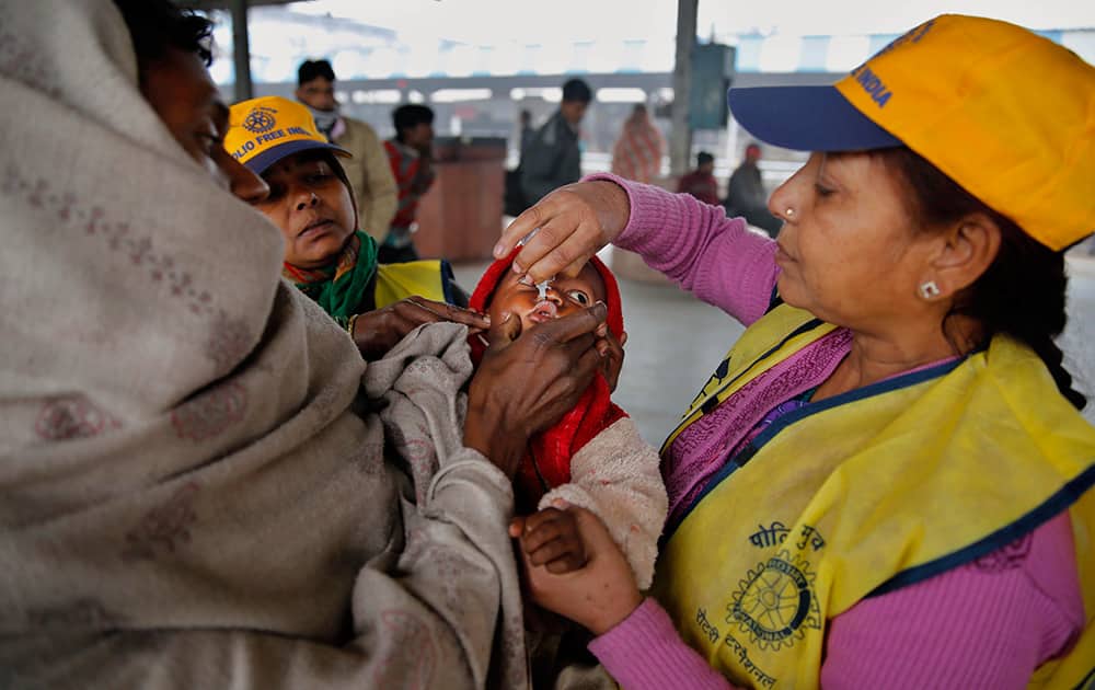 A medical volunteer administers polio immunization drops to a child at a railway station in Allahabad.