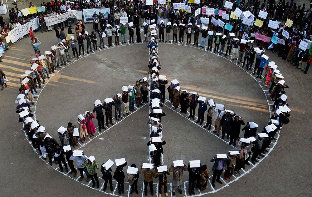 Activists from a human rights group known as National Commission for Justice and Peace form a peace sign during a demonstration demanding to effort for peace in the country, in Lahore.