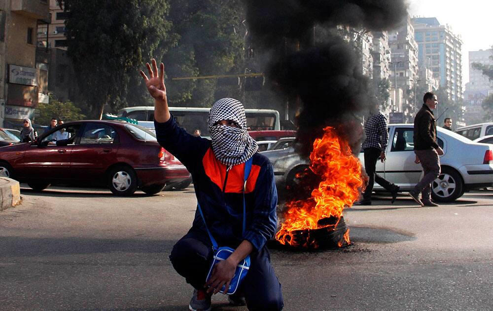 A supporter of ousted leader Mohammed Morsi flashes the `Rabaa` sign during a protest in Nahda Square, near Cairo University in Giza, Egypt.