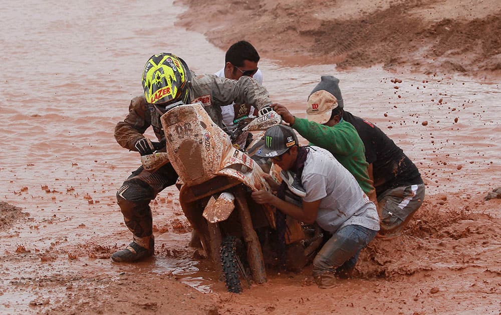 After falling from his motorbike, KTM rider Stephane Hamard of France gets help pushing his bike out of a mud puddle during the seventh stage of the Dakar Rally between the cities of Salta, Argentina and Uyuni, Bolivia.