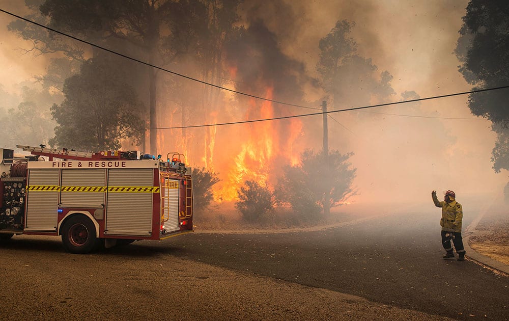 In this image released by the Department of Fire and Emergency Services, a firefighter directs a fire truck in Perth Hills in western Australia.