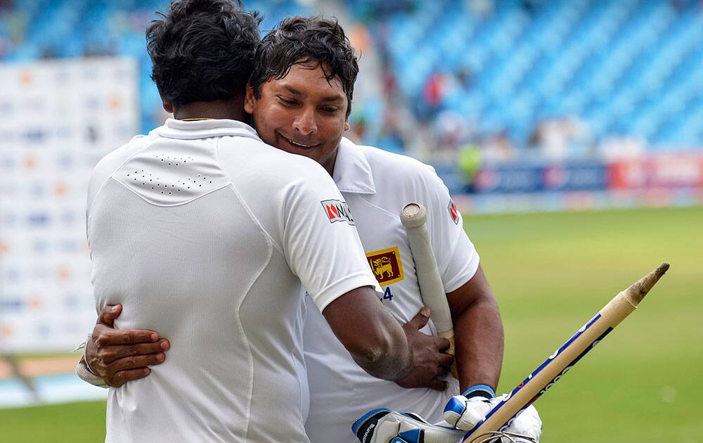 Sri Lanka captain Angelo Mathews, right, congratulates batsman Kumar Sangakarra after winning the match during the second cricket test match between Pakistan and Sri Lanka at the Dubai International Cricket Stadium.