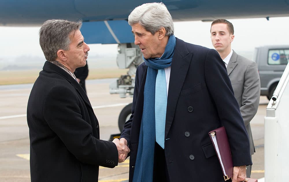 US Secretary of State John Kerry, right, is greeted on the tarmac upon his arrival in Paris, France, by Mark Taplin, left, who is the Charge d`Affaires at the US Embassy.