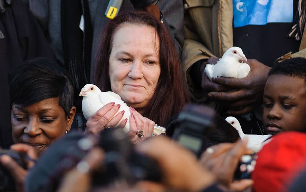 Pam Duggan, centre, the mother of Mark Duggan, prepares to release a white dove at a vigil in his memory outside Tottenham Police Station, in Tottenham, north London.