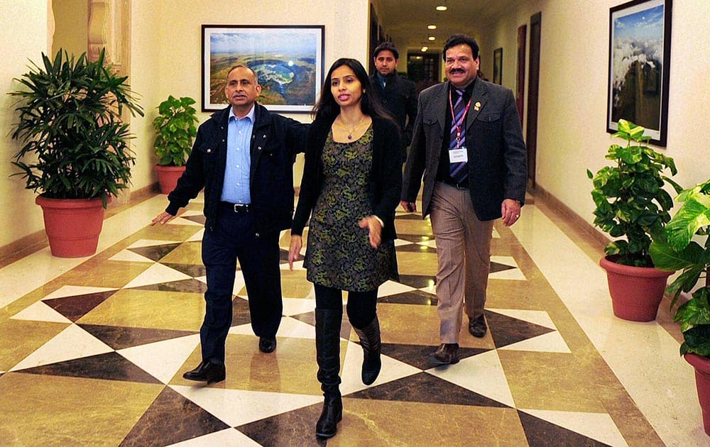 Devyani Khobragade, center, who served as India’s deputy consul general in New York, walks with her father Uttam Khobragade after her arrival in New Delhi.