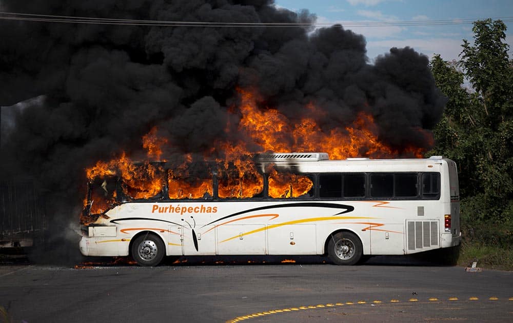 A bus burns at the entrance of Paracuaro, Mexico. Residents of villages near Paracuaro set at least six cars and trucks on fire to protest the arrival of more than 100 vigilantes to their town in the western state of Michoacan.