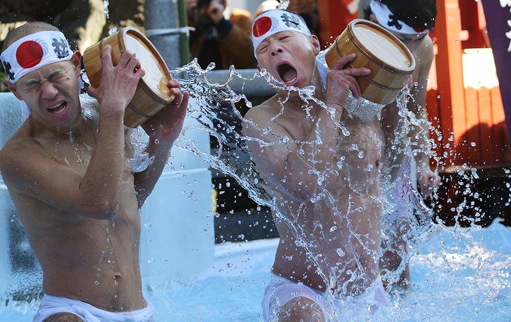 Half-naked shrine parishioners using wooden tubs pour cold water onto themselves during an annual cold-endurance festival at the Kanda Myojin Shinto shrine in Tokyo.
