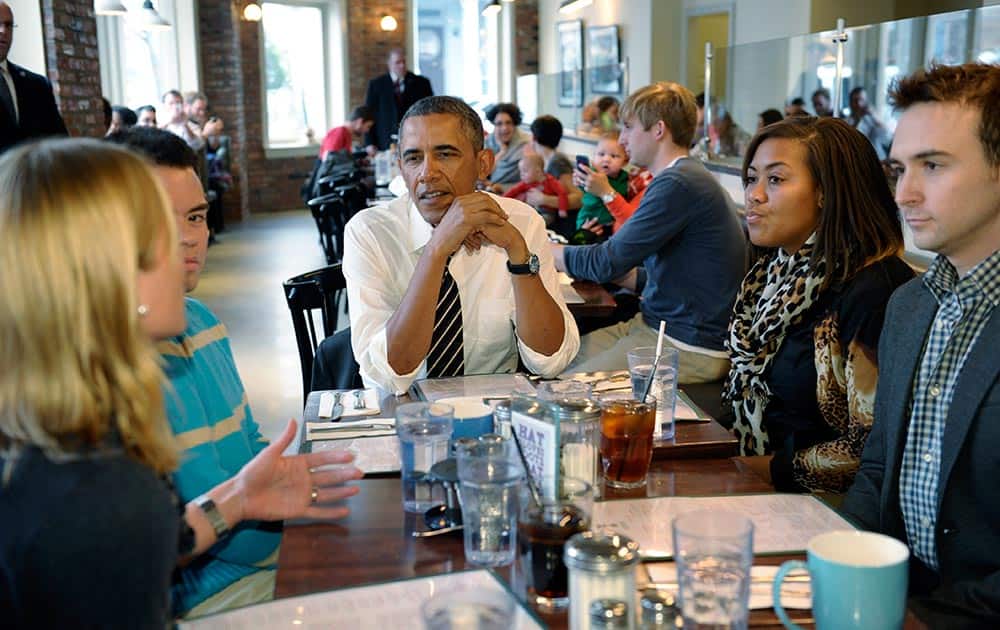 President Barack Obama listens as he has lunch with five young people at The Coupe restaurant in the Columbia Heights section of Washington.