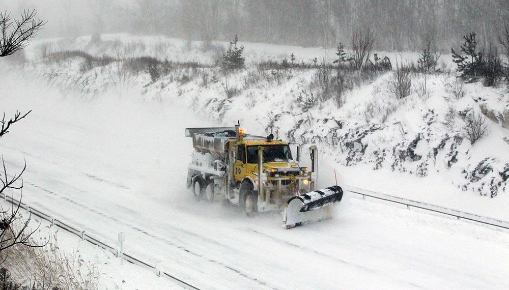 A plow moves along a empty stretch of the New York State thruway in Hamburg,N.Y., after it was closed down due to high winds.